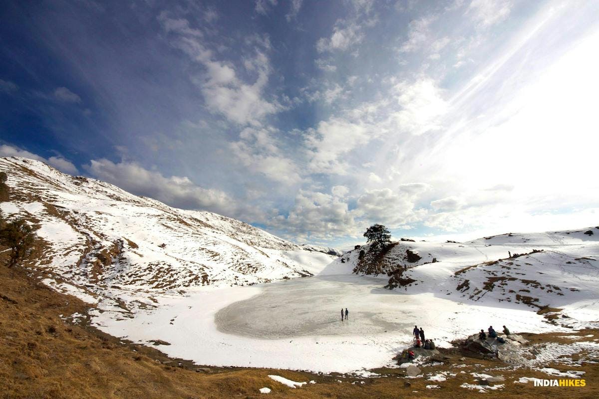 Trekkers walking on top of the frozen Brahmatal Lake in winter when the lake has frozen over