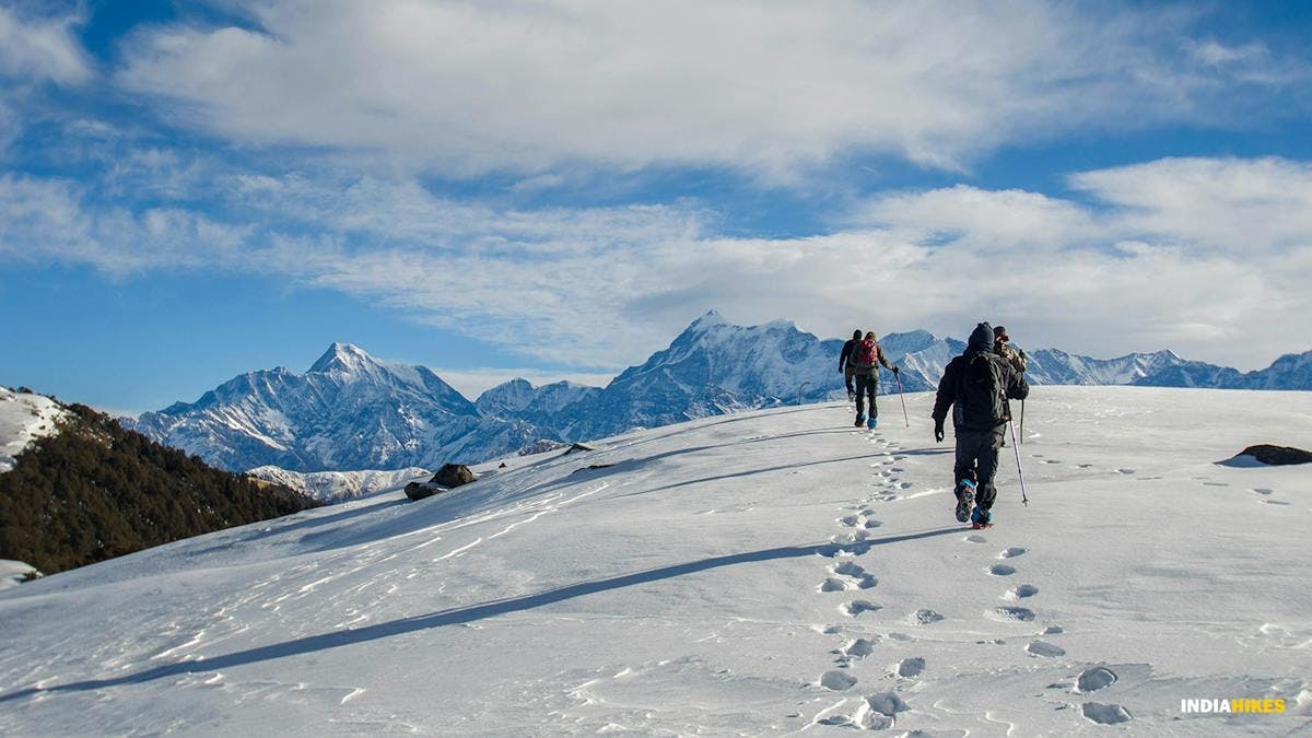 A group of trekkers enjoying the walk on crisp snow towards their way to the Brahmatal Lake