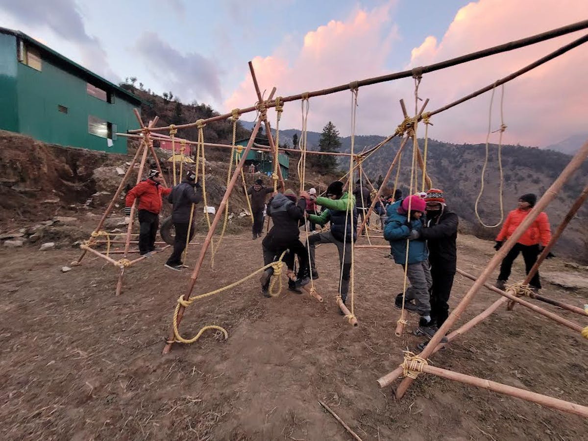 Close-up of trekkers tackling the obstacles on the rope course at Raithal, focusing on their determined expressions and hand and foot placement. Photo by Lay Naik. 