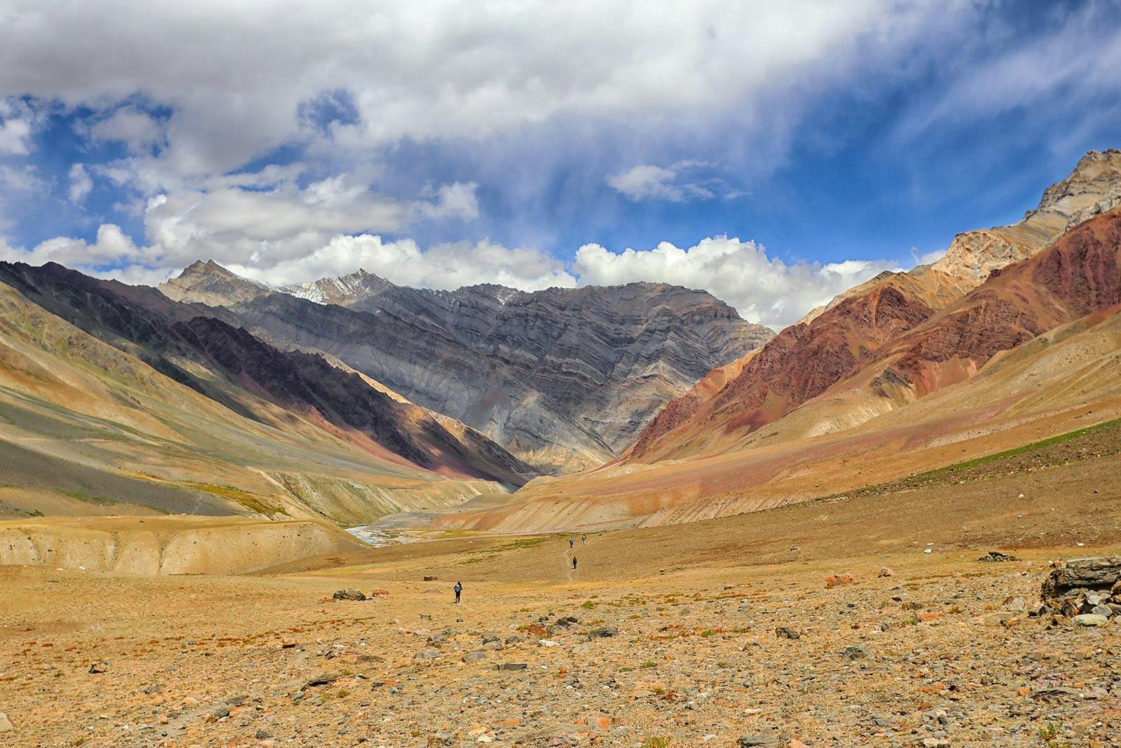 A group of trekkers walking in the dry meadows of Pin Bhaba Pass