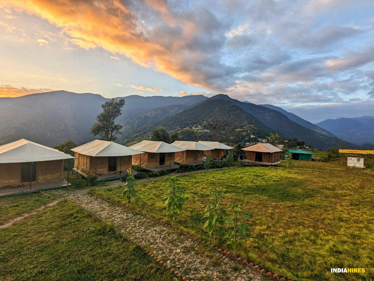 Indiahikes campus at Lohajung consisting of many Swiss tents nestled among green mountains