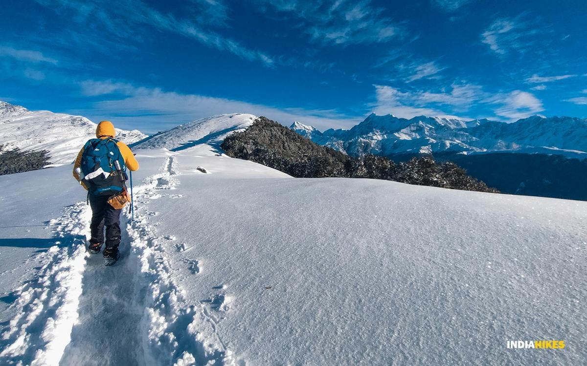 A trekker following the trail through deep snow on the ridgewalk from Jhandi Top to Brahmatal Top